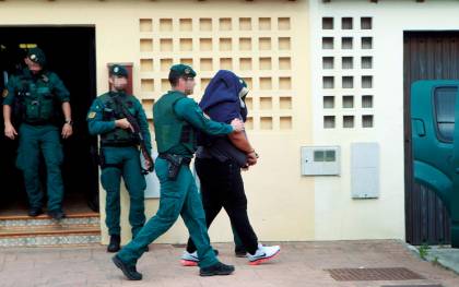 Agentes de la Guardia Civil trasladan a un detenido durante uno de los registros realizados en una vivienda de la calle Espartel en la barriada del rinconcillo en Algeciras (Cádiz). EFE/A.Carrasco Ragel.