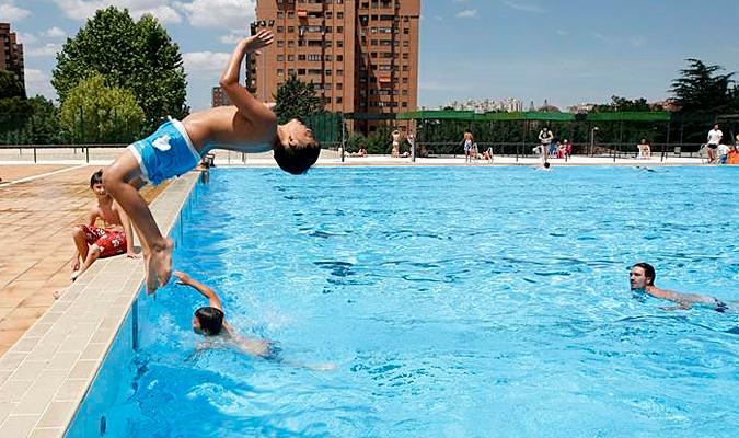 Un niño se lanza a una piscina. / EFE