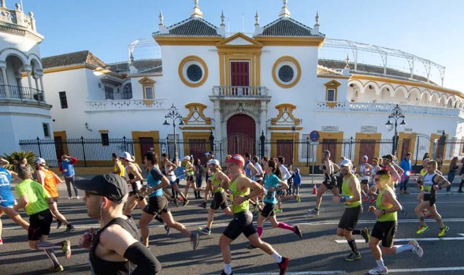 Participantes del maratón del pasado año pasan junto a la Real Maestranza de Sevilla. /El Correo
