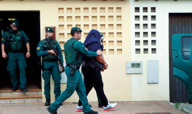 Agentes de la Guardia Civil trasladan a un detenido durante uno de los registros realizados en una vivienda de la calle Espartel en la barriada del rinconcillo en Algeciras (Cádiz). EFE/A.Carrasco Ragel.