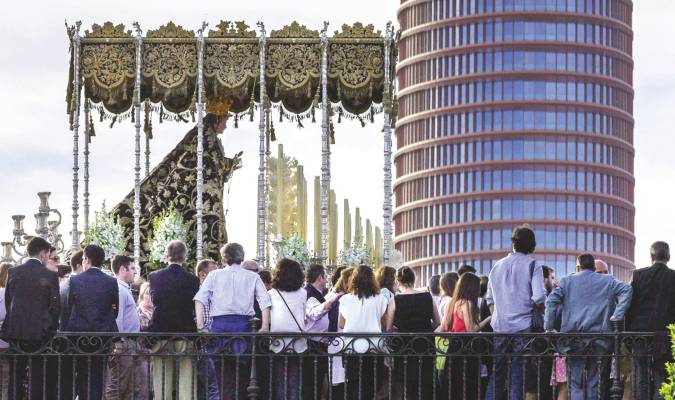 El paso de palio de la Virgen de La Estrella, de la Hermandad del mismo nombre, pasando por el puente de Triana, con la Torre Pelli al fondo, durante su recorrido procesional del Domingo de Ramos en Sevilla. EFE/Julio Muñoz