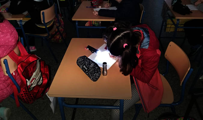 Una escolar con una linterna en su pupitre. Foto: El Correo.