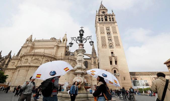 Turistas pasean por las inmediaciones de la Catedral y la Torre de la Giralda de Sevilla. EFE/José Manuel Vidal