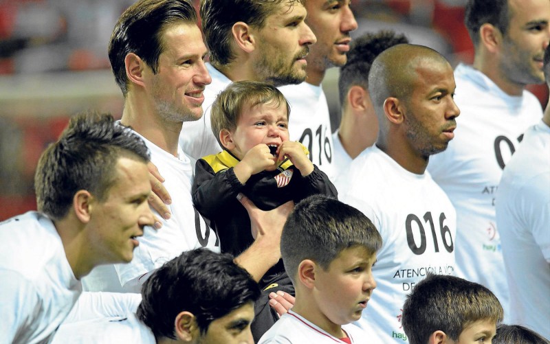 Un joven aficionado llora durante la foto del equipo con los más pequeños junto a Krychowiak y Mariano. / Manuel Gómez