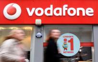 Foto de archivo de varios viandantes mientras pasan delante de un establecimiento de la compañía de telecomunicaciones Vodafone en Londres (Reino Unido).EFE/Andy Rain