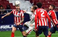 El defensa del Atlético de Madrid Mario Hermoso (i) lucha con el croata Ivan Rakitic (2i), del Sevilla FC. EFE/JuanJo Martín