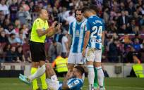 El árbitro Antonio Mateu Lahoz conversa con varios jugadores del RCD Espanyol tras una jugada contra el FC Barcelona, durante el partido de la jornada 15 de LaLiga disputado en el Camp Nou de Barcelona. EFE/Marta Pérez