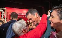 El secretario general del PSOE y presidente del Gobierno, Pedro Sánchez, recibe el abrazo de una mujer momentos antes de participar en un acto-mitin de los socialistas en el teatro municipal de Baza (Granada).EFE/Miguel Ángel Molina
