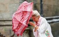 Una mujer se protege del viento y la lluvia en Santiago de Compostela. EFE/Lavandeira jr