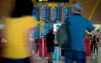 Imagen de archivo de varios pasajeros junto a paneles informativos de salidas en el Aeropuerto Adolfo Suárez Madrid-Barajas. EFE/Luca Piergiovanni