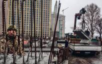 Varios operarios cargan losas de cementoen Kiev (Ucrania). / E.P.