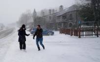 Dos personas caminan por una acera nevada. / E.P.