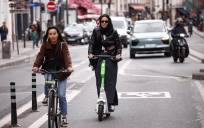 Usuarios de patinetes eléctricos de alquiler por las calles de París. (Francia) EFE/EPA/YOAN VALAT