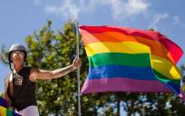 Un hombre ondea una bandera del arcoiris durante su participación en el desfile anual del Orgullo Gay en París. EFE/Ian Langsdon