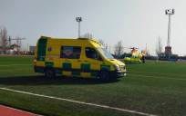 La ambulancia en la que ha sido evacuado el niño, junto al helicóptero en el polideportivo de Lepe.