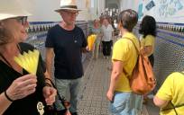 Integrantes de Escuelas de Calor entregan abanicos amarillos a los votantes el pasado 23 de julio.
