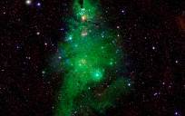 Observatorios astronómicos de la Nasa han captado un conjunto de estrellas jóvenes, situadas a unos 2.500 años luz de la Tierra, y ha realzado los colores y figuras que forman este conjunto de luces para compararlo un árbol de Navidad. Imagen: Nasa