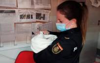 Imagen de una agente de la Policía Nacional con el bebé. / E.P.