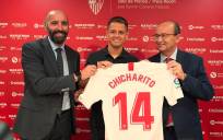 ‘Chicharito’ posa con la camiseta del Sevilla junto a Monchi y José Castro. / SFC