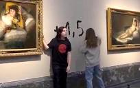 Captura de vídeo del momento en el que dos activistas se han pegado a los marcos de los cuadros de "La maja vestida" y "La maja desnuda" del Museo del Prado y han escrito en la pared '+1.5°'. EFE/Futuro Vegetal