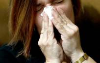 Una mujer con síntomas de gripe. / EFE