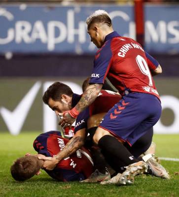 Los jugadores de Osasuna Rubén García (c) y Chimy Ávila (d) acuden en ayuda de su compañero Marc Cardona (i) que cayó al suelo tras un encontronazo con un jugador del Sevilla. EFE/Jesús Diges
