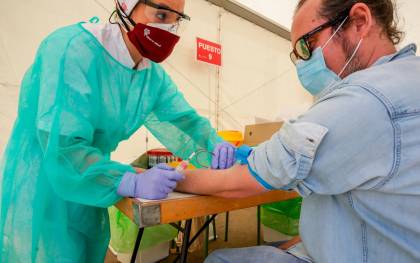 Una trabajadora sanitaria totalmente protegida, realiza una prueba diagnóstica del coronavirus. / Ricardo Rubio / E.P.