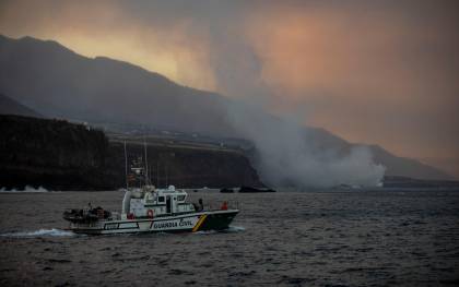 Un barco de la Guardia Civil navega cerca de la columna de humo y la lava del volcán de Cumbre Vieja a su llegada al Océano Atlántico. / E.P.