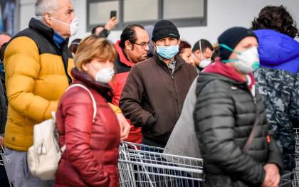 Residentes italianos esperan la entrada al mercado en la zona de Lombardía. / Efe