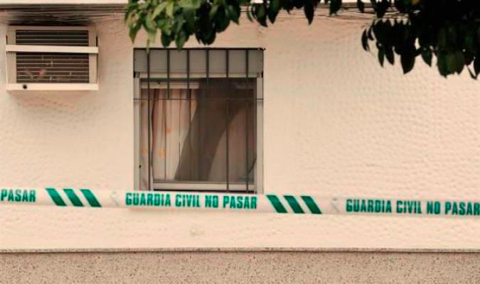 Ventana del domicilio en Lora del Río donde la Guardia Civil localizó los cadáveres de una pareja de ancianos de 84 y 91 años. / Efe
