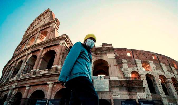 Un hombre camina junto al Coliseo romano con mascarilla. / El Correo.