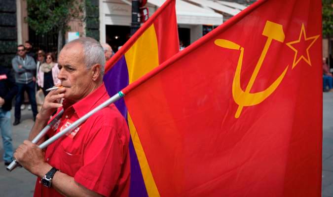 Un manifestante con las banderas republicana y del Partido Comunista espera fumando la salida de una manifestación. EFE/Julio Muñoz