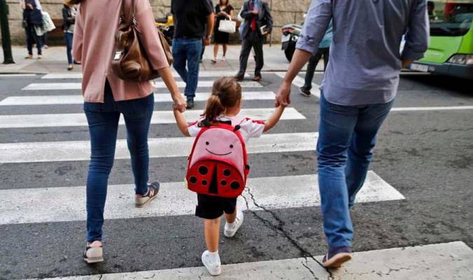 Unos padres llevan a su hija al colegio. / EFE