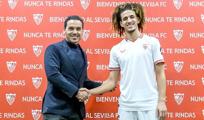 El presidente del Sevilla FC, José María del Nido Carrasco (i), estrecha la mano al centrocampista tunecino de 21 años Hannibal Mejbri, durante su presentación como nuevo jugador sevillista. EFE/ Raúl Caro.