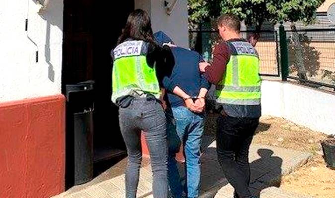 Dos agentes conducen a un detenido al interior de la Comisaría de Policía de Nervión. / Policía Nacional
