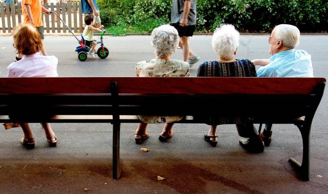 Pensionistas sentados en un parque.
