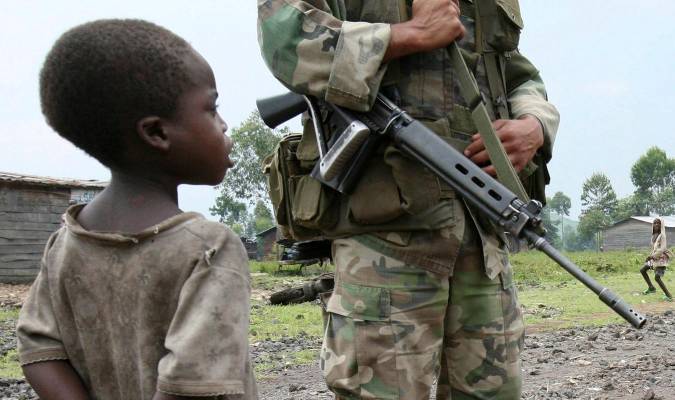 En la imagen de archivo, un niño observa junto a un soldado uruguayo de la Misión de la ONU en República Democrática del Congo (Monuc) mientras patrulla en el campo de refugiados de Kibati. / EFE