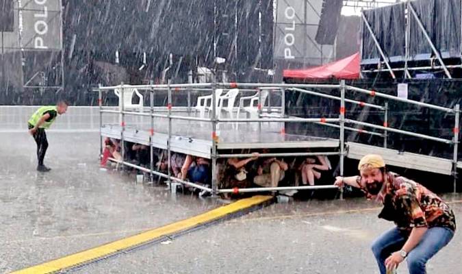 Imagen de los asistentes debajo de una plataforma cuando sorprendió la tormenta. / Marian Flandes (@marianflandes) - Twitter