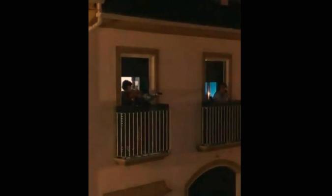 Marcos toca el himno de Sevilla con su violín desde el balcón. / Twitter
