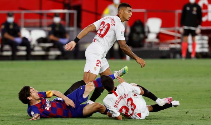 El delantero argentino del FC Barcelona, Leo Messi (i), cae ante el defensa del Sevilla, Sergio Reguilón. EFE/Jose Manuel Vidal.