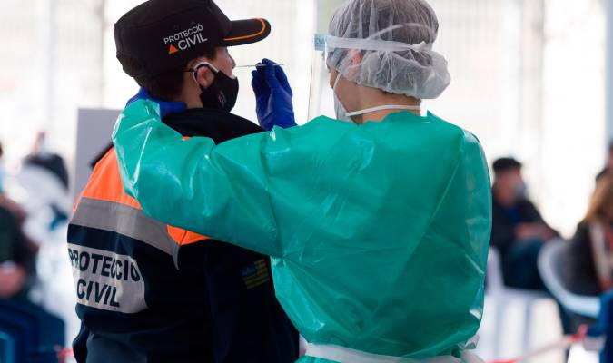 Una trabajadora sanitaria protegida realiza un test de antígenos. / E.P.