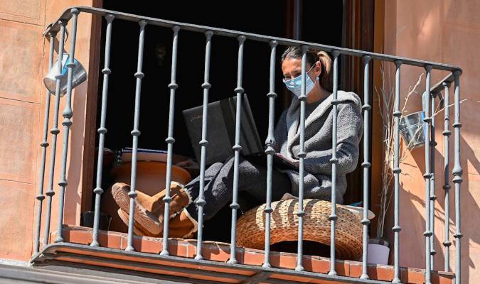 Una mujer en el balcón de su vivienda durante el confinamiento. / EFE | Fernando Villar