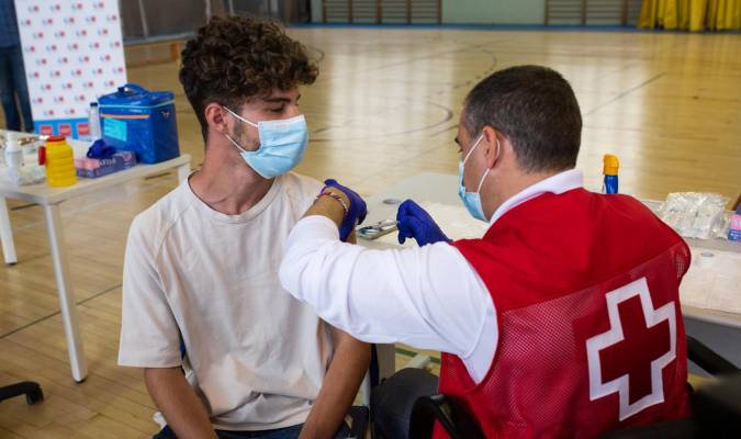 Un voluntario de Cruz Roja administra una dosis de la vacuna contra el Covid-19 a un estudiante universitario. / E.P.