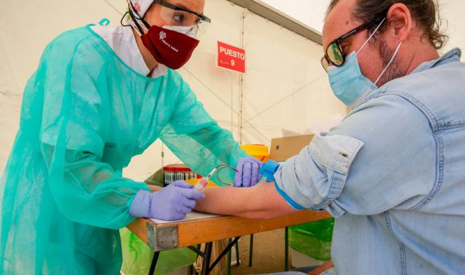 Una trabajadora sanitaria totalmente protegida, realiza una prueba diagnóstica del coronavirus. / Ricardo Rubio / E.P.