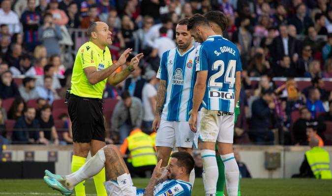 El árbitro Antonio Mateu Lahoz conversa con varios jugadores del RCD Espanyol tras una jugada contra el FC Barcelona, durante el partido de la jornada 15 de LaLiga disputado en el Camp Nou de Barcelona. EFE/Marta Pérez