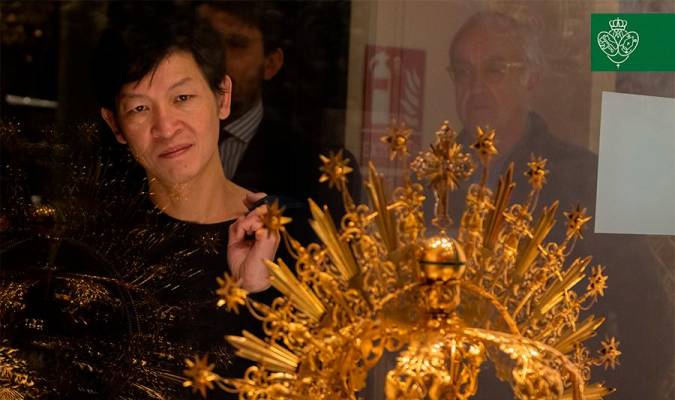El creador vietnamita contempla la corona de oro de la Macarena en una anterior visita a Sevilla. Foto: Hermandad de la Macarena