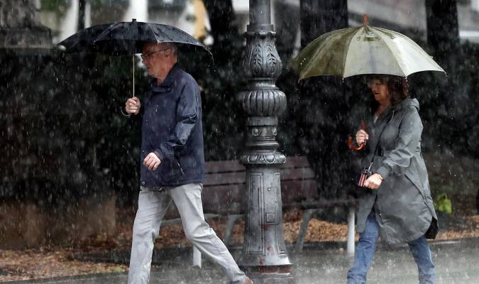 Dos personas se protegen de la lluvia. EFE/ Jesús Diges