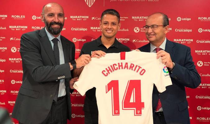 ‘Chicharito’ posa con la camiseta del Sevilla junto a Monchi y José Castro. / SFC