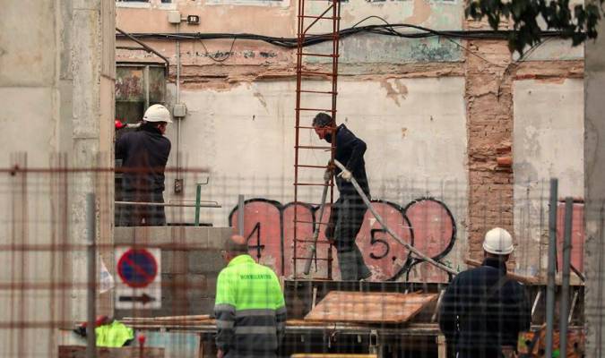 Varios trabajadores de la construcción en una de las obras que siguen activas en Valencia. / Efe