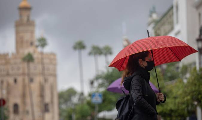 Una mujer bajo su paraguas durante una jornada de lluvia en Sevilla. / El Correo